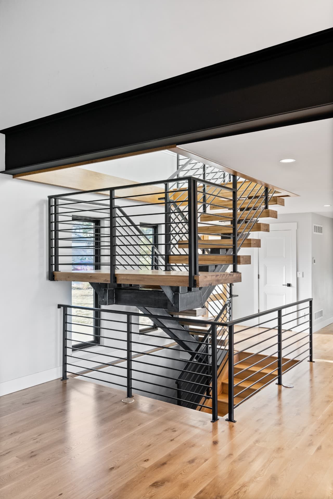 Steel and oak open stair seen from the main level