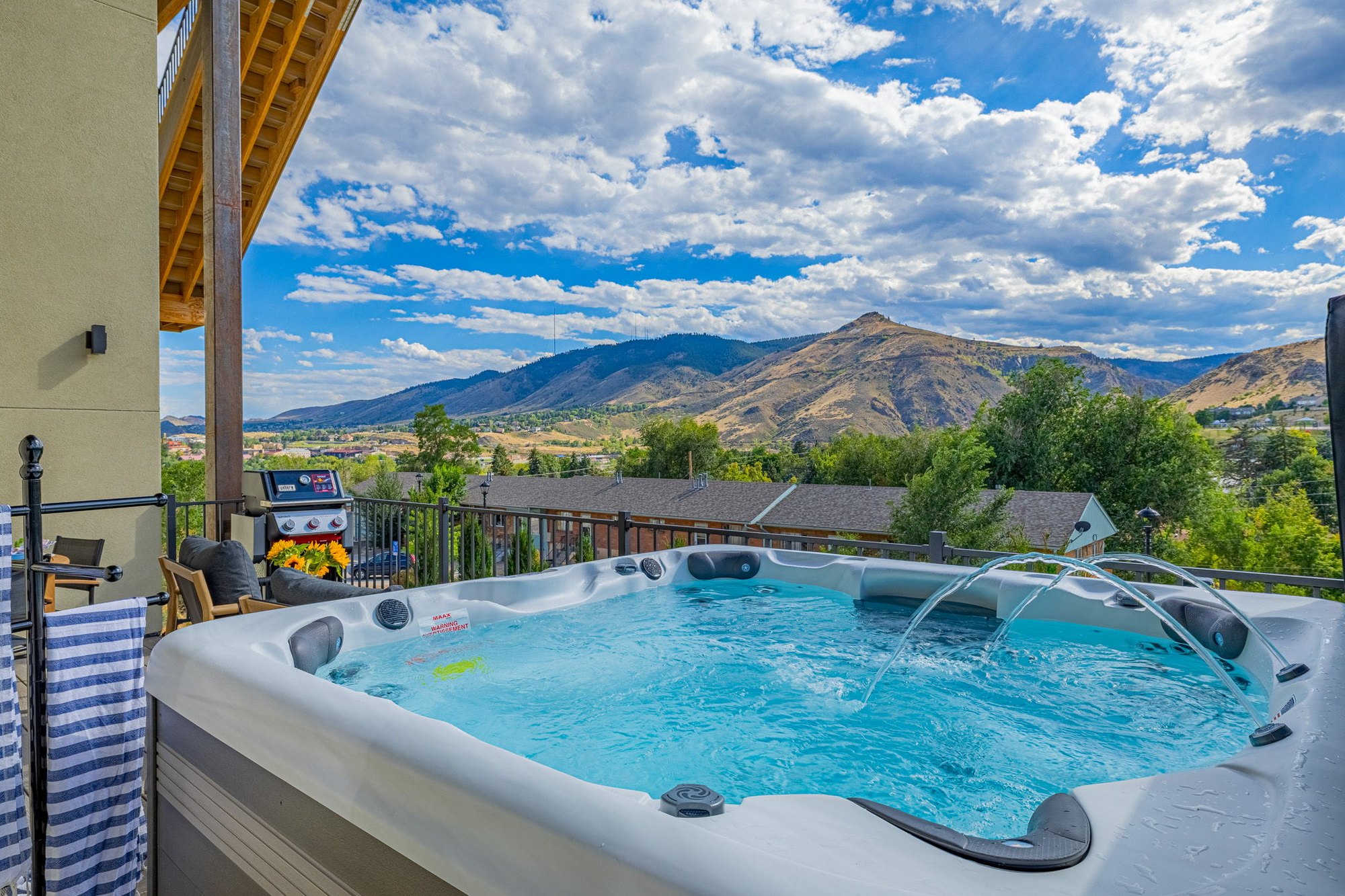 Hot tub on the deck with water jets running and mountains behind