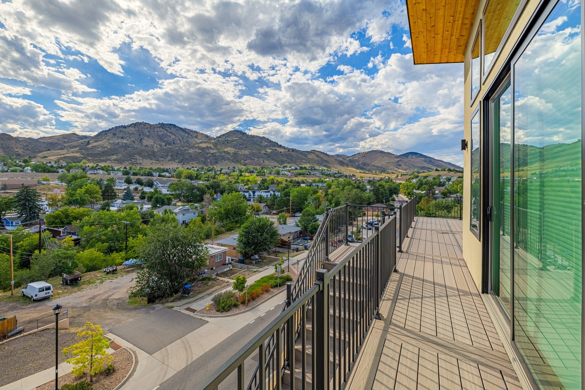 Composite deck running the length of the house with a steel railing and a valley view