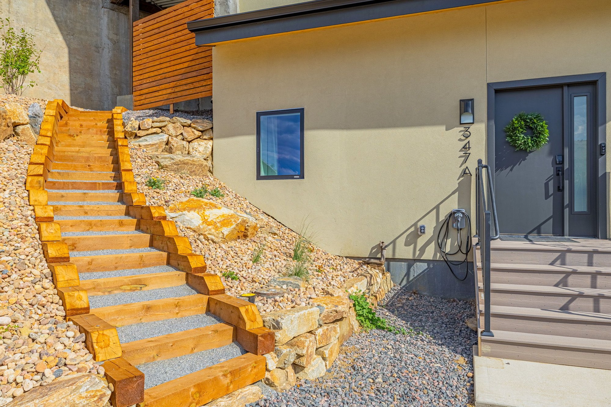 Timber and gravel stair climbing the hillside beside the house