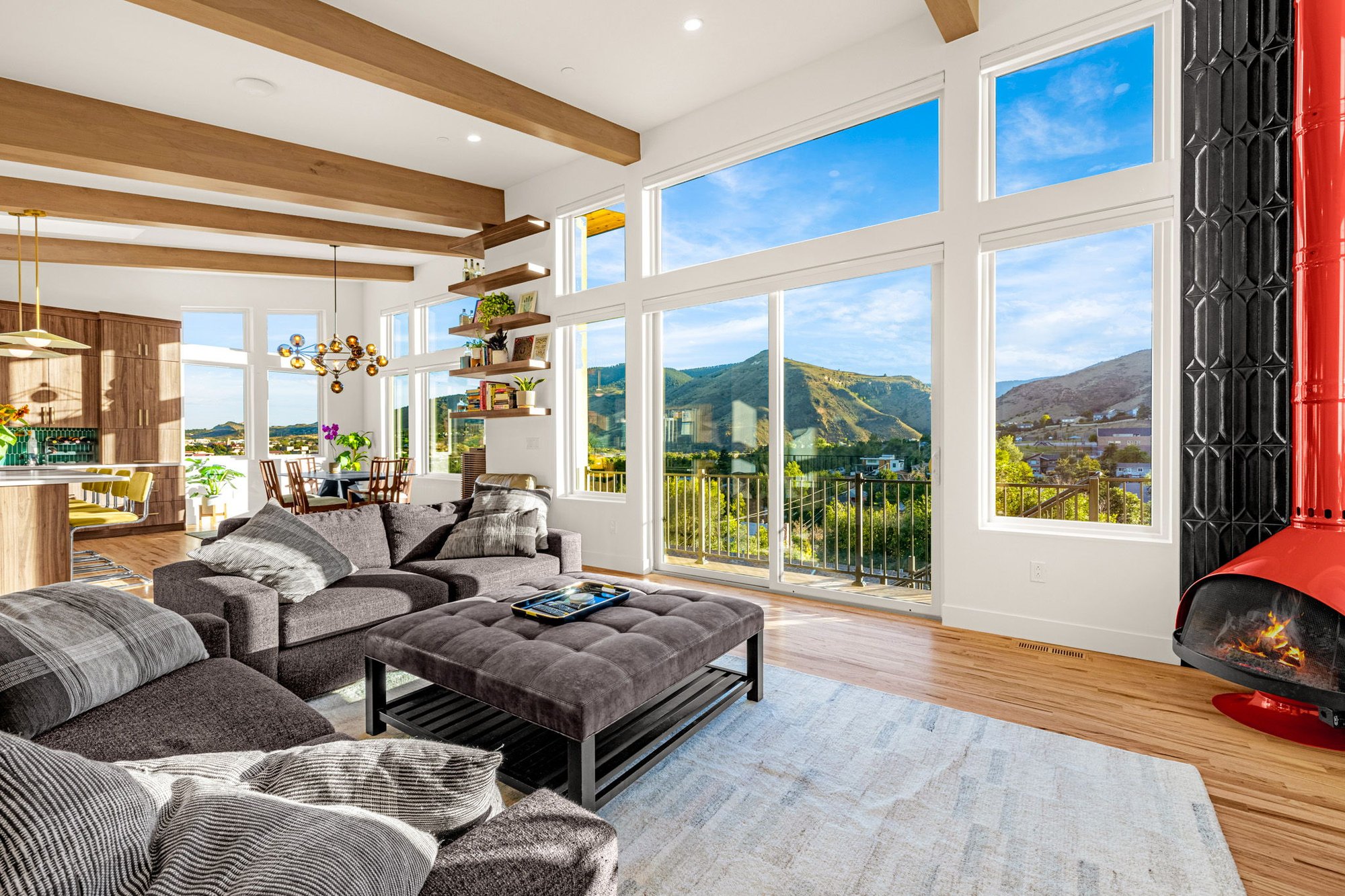 Open living room with vaulted ceiling, exposed beams and floor-to-ceiling windows onto the Golden foothills