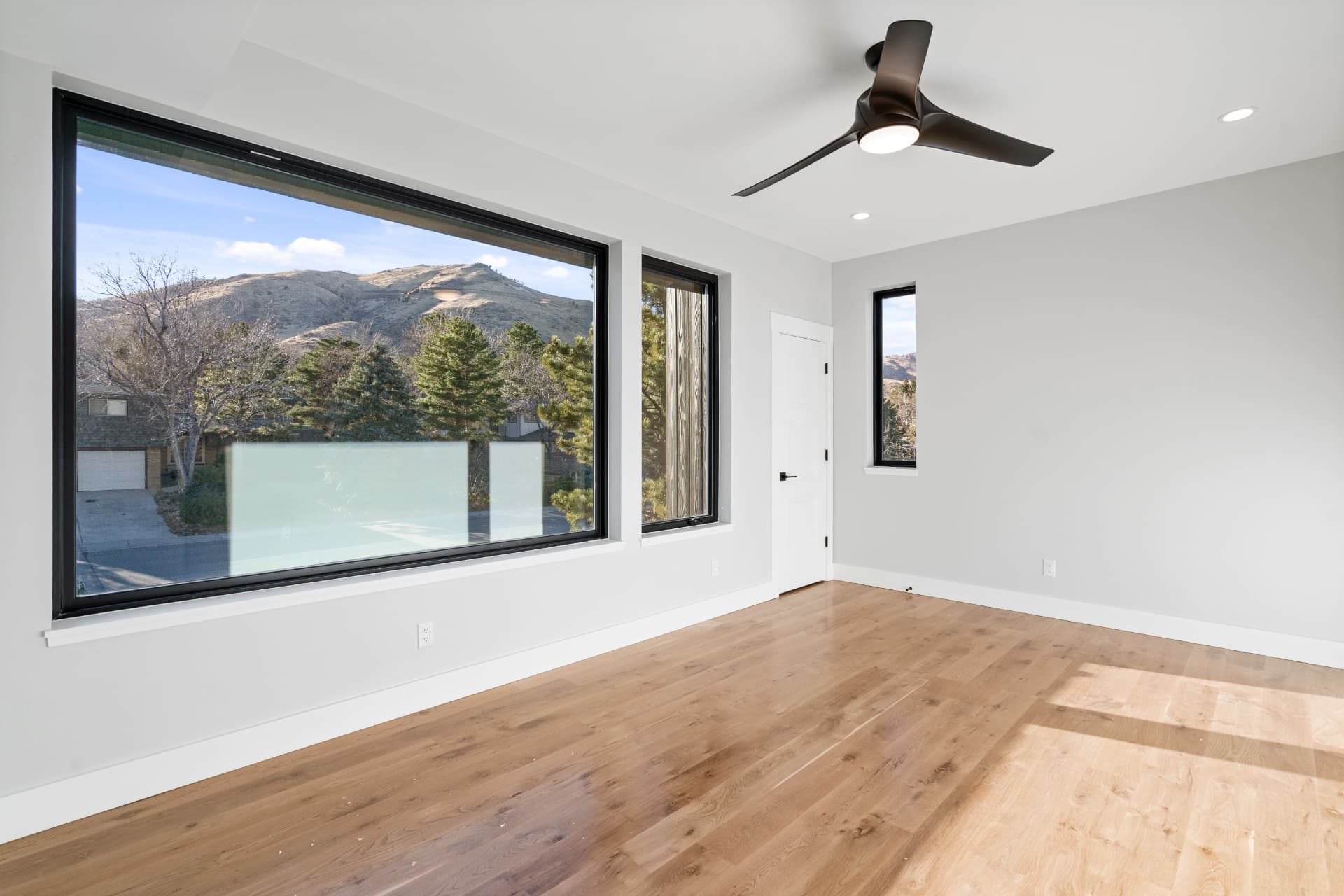 Bedroom with a large picture window framing the foothills