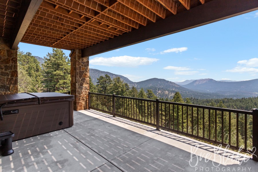 Covered lower patio with stone columns and mountain views