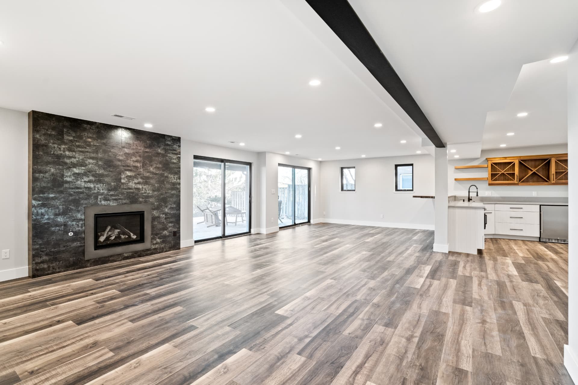 Open living room with a dark tile fireplace wall and sliding patio doors