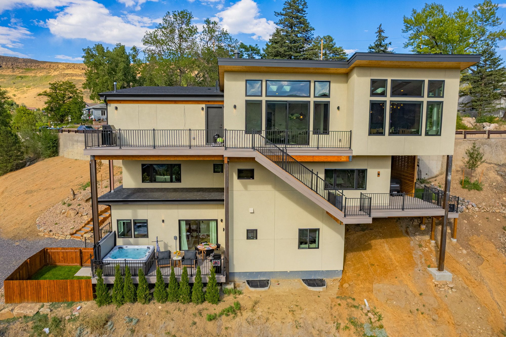 Rear elevation of a custom home in Golden showing two levels of deck and an exterior stair