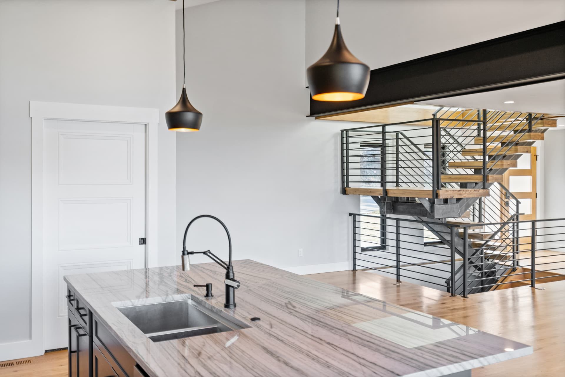 Kitchen island and steel stair railing in the open main level