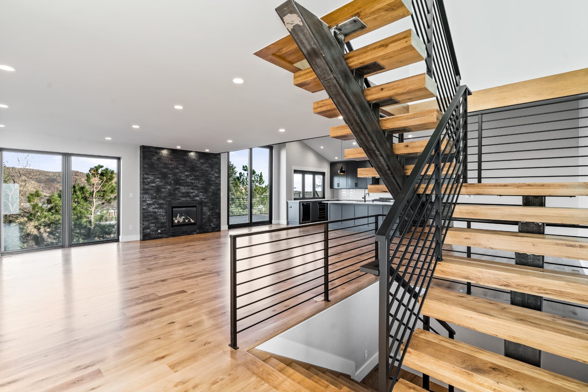 Living room and open stair with full-height windows onto the foothills