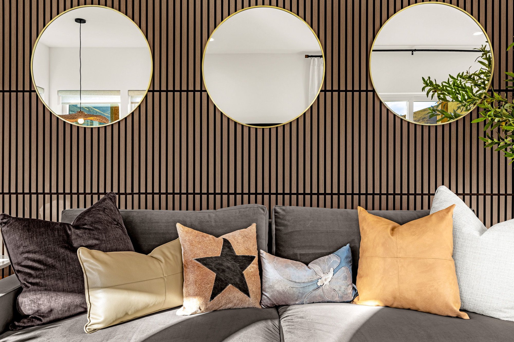 Detail of the slat wall and round mirrors above the sofa