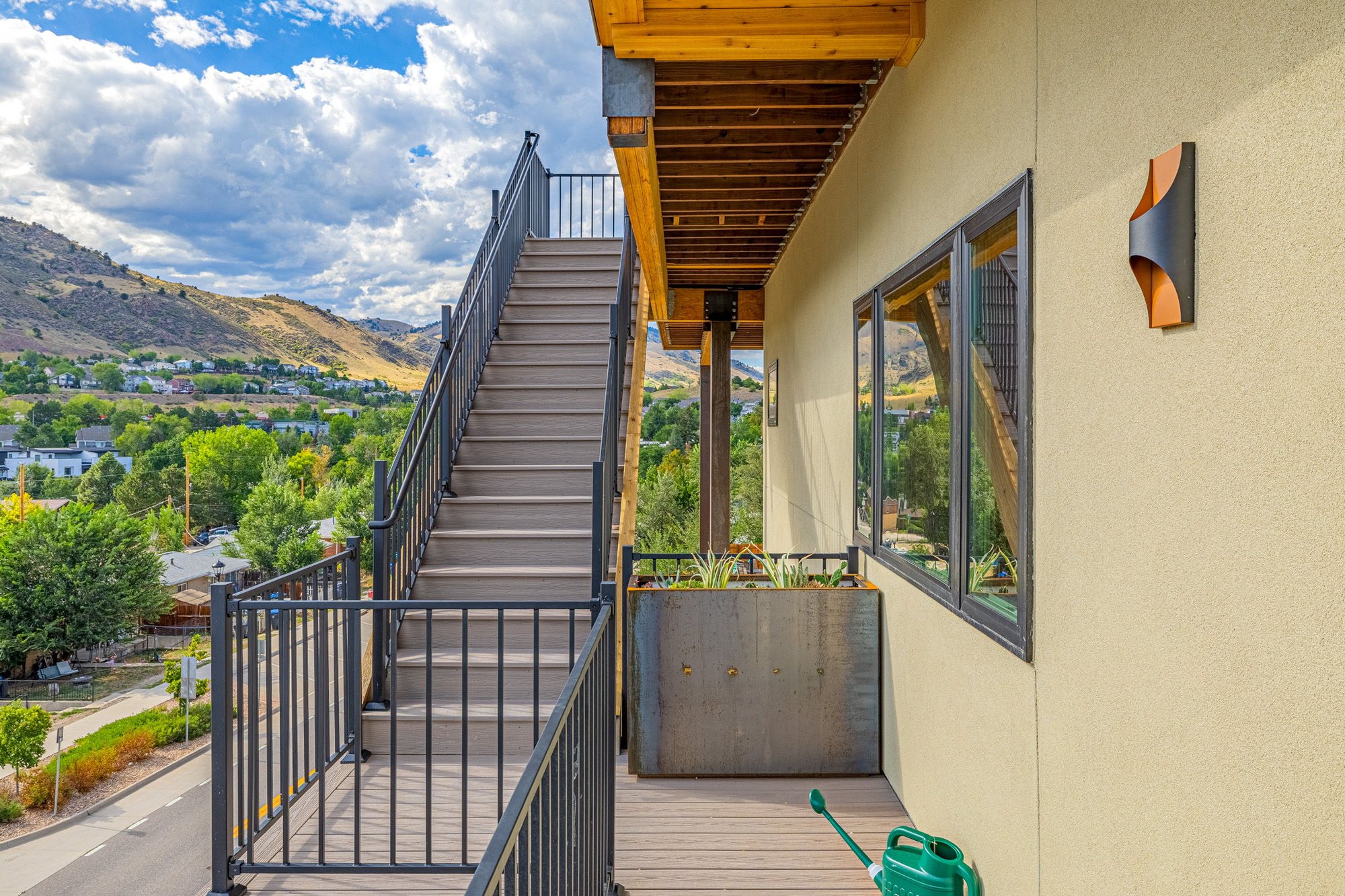 Steel and composite exterior stair rising along the side of the house