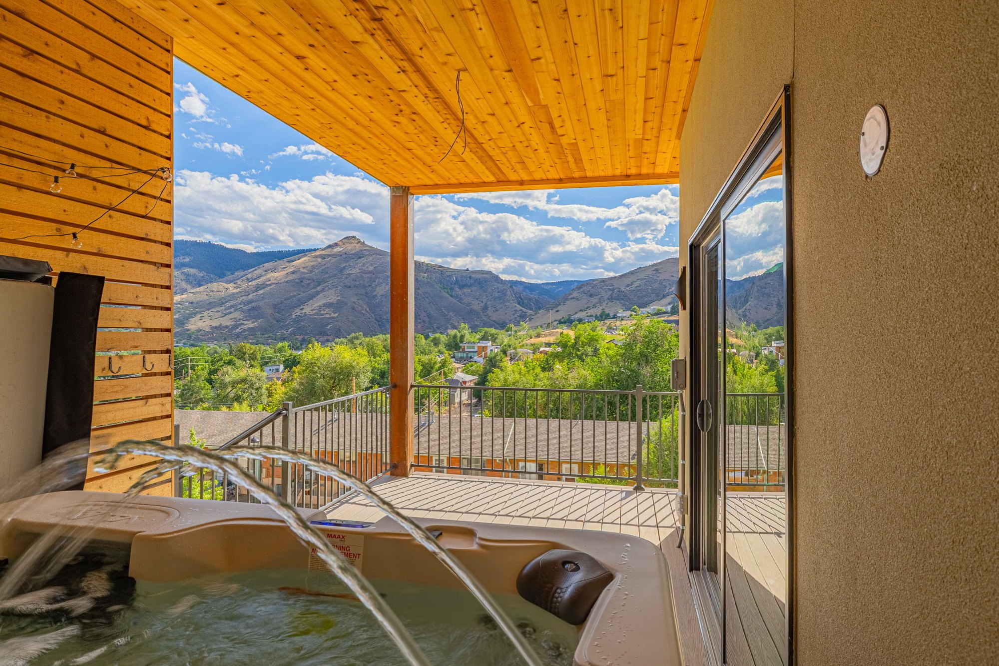 Hot tub set beneath a cedar-clad pergola on the upper deck