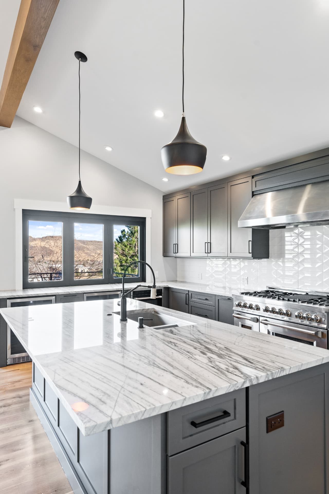 Kitchen island in marble with a mountain view through the window wall