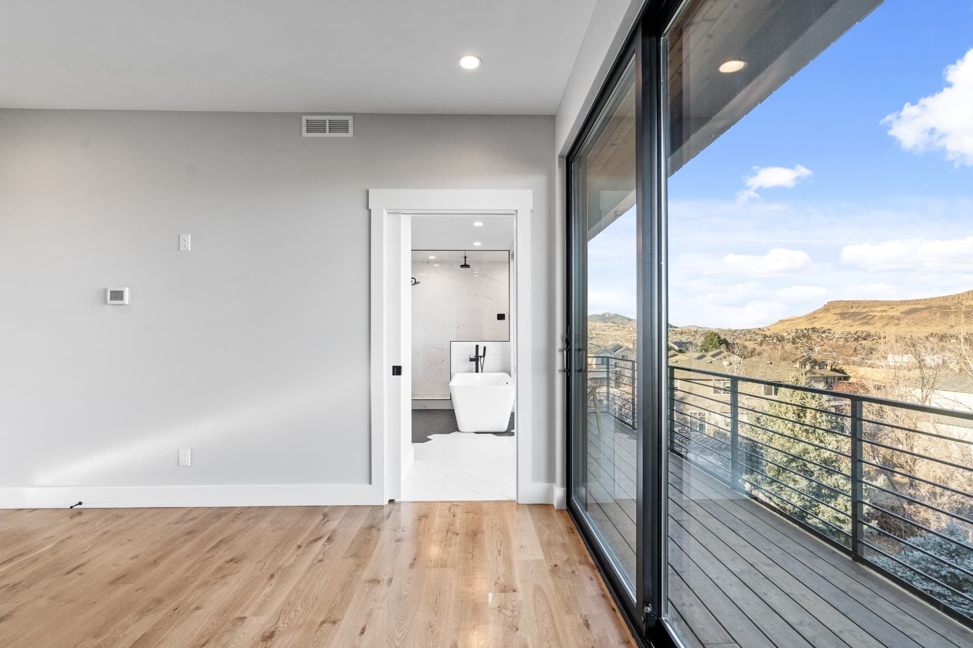 Primary bedroom with full-height sliding doors onto the balcony