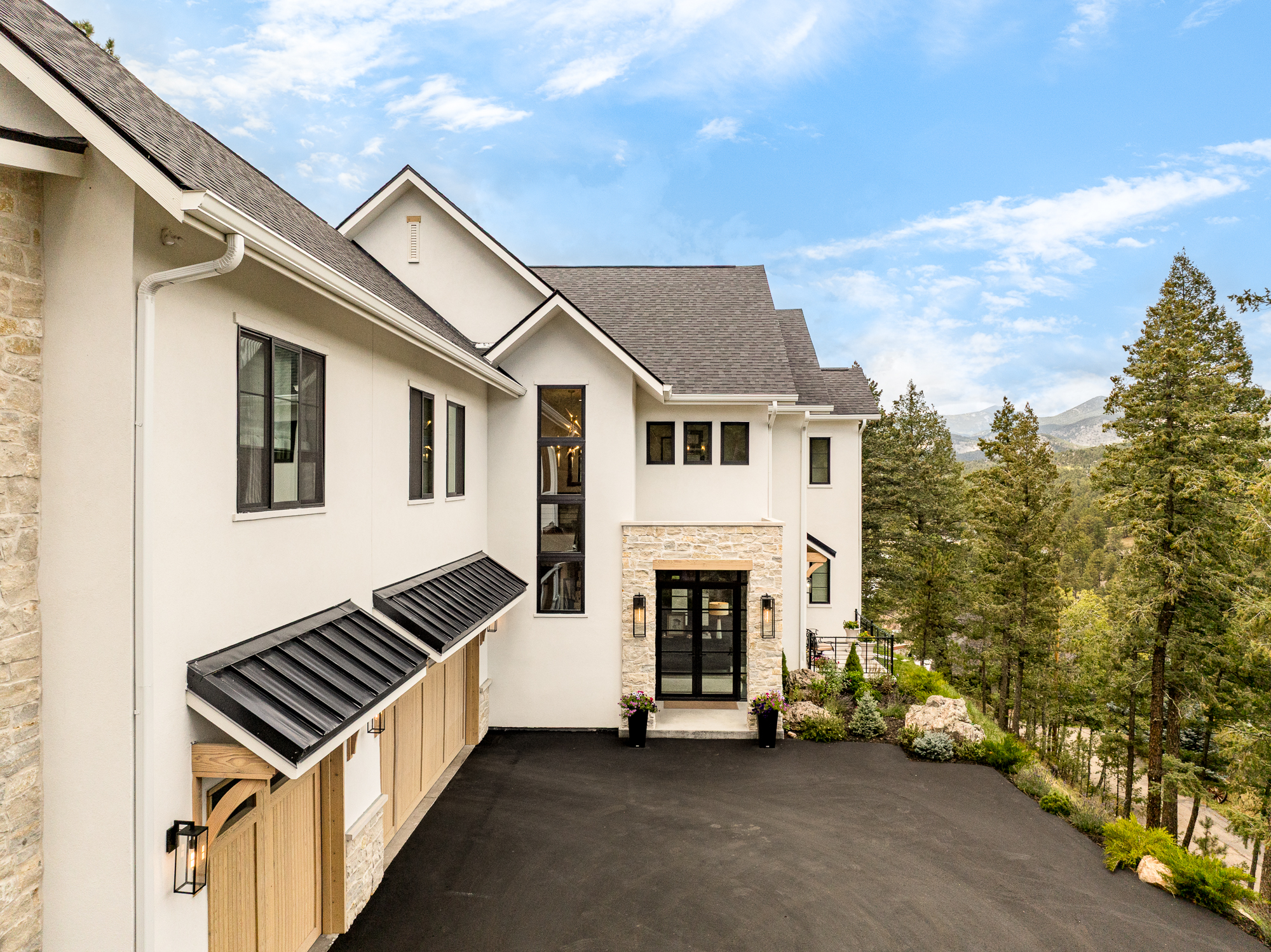 Front exterior of the Evergreen Home with stone accents and mountain views