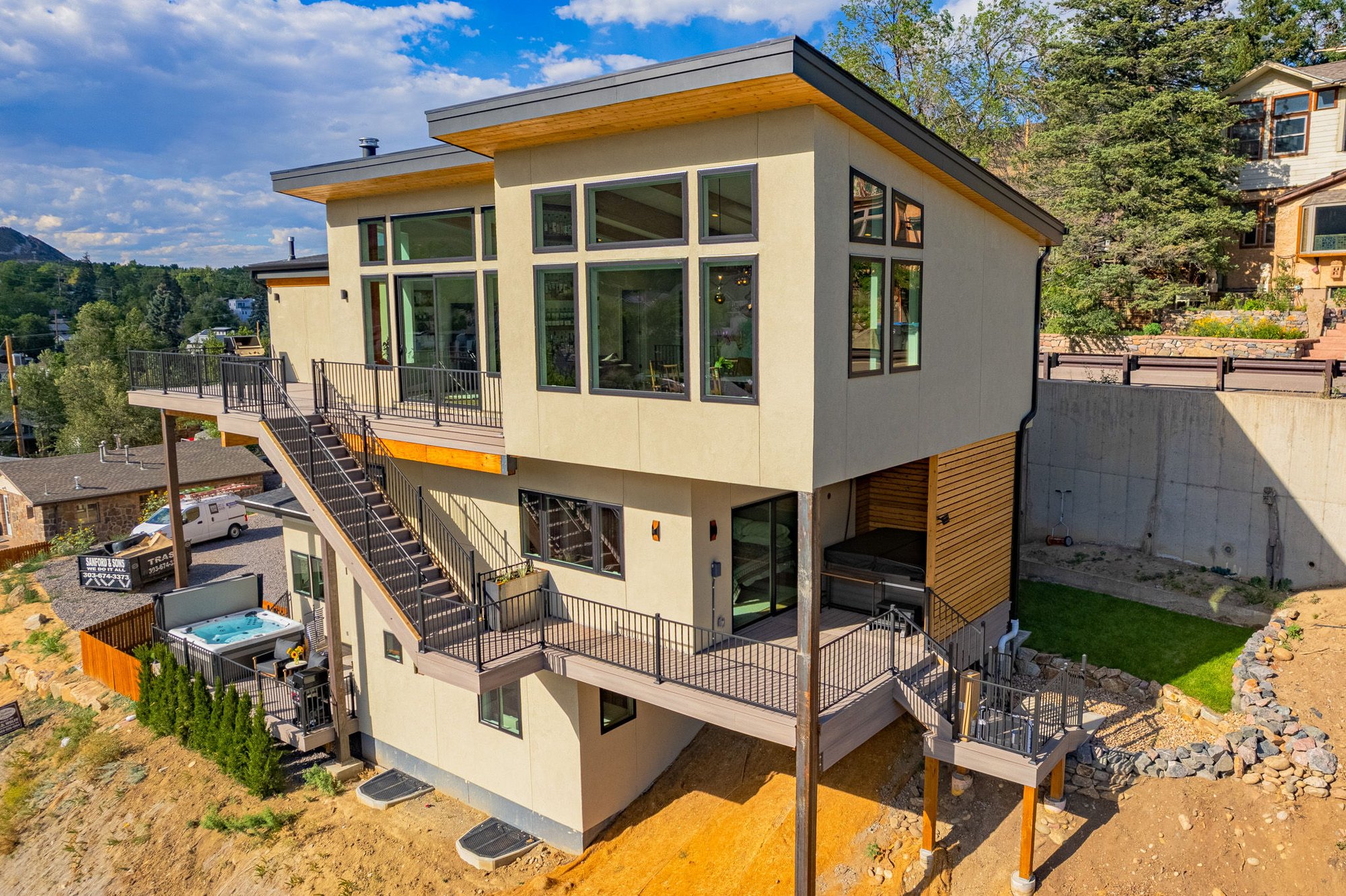 Aerial view of a modern hillside home in Golden, Colorado, with multi-level decks