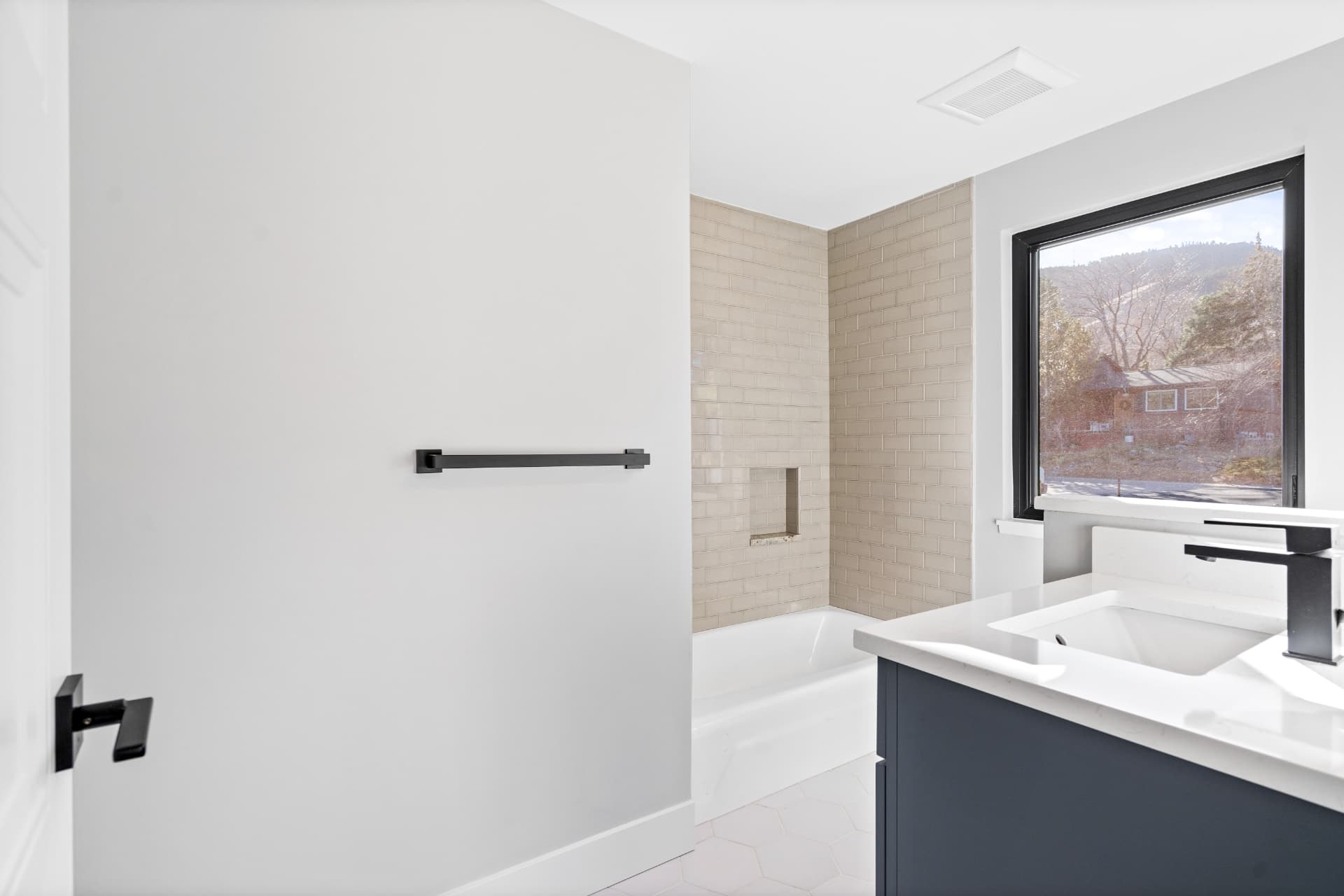 Bathroom with a tiled tub surround and a mountain-view window