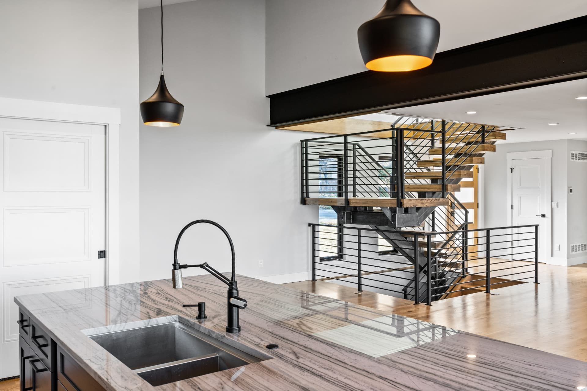 Kitchen island sink looking across to the open stair