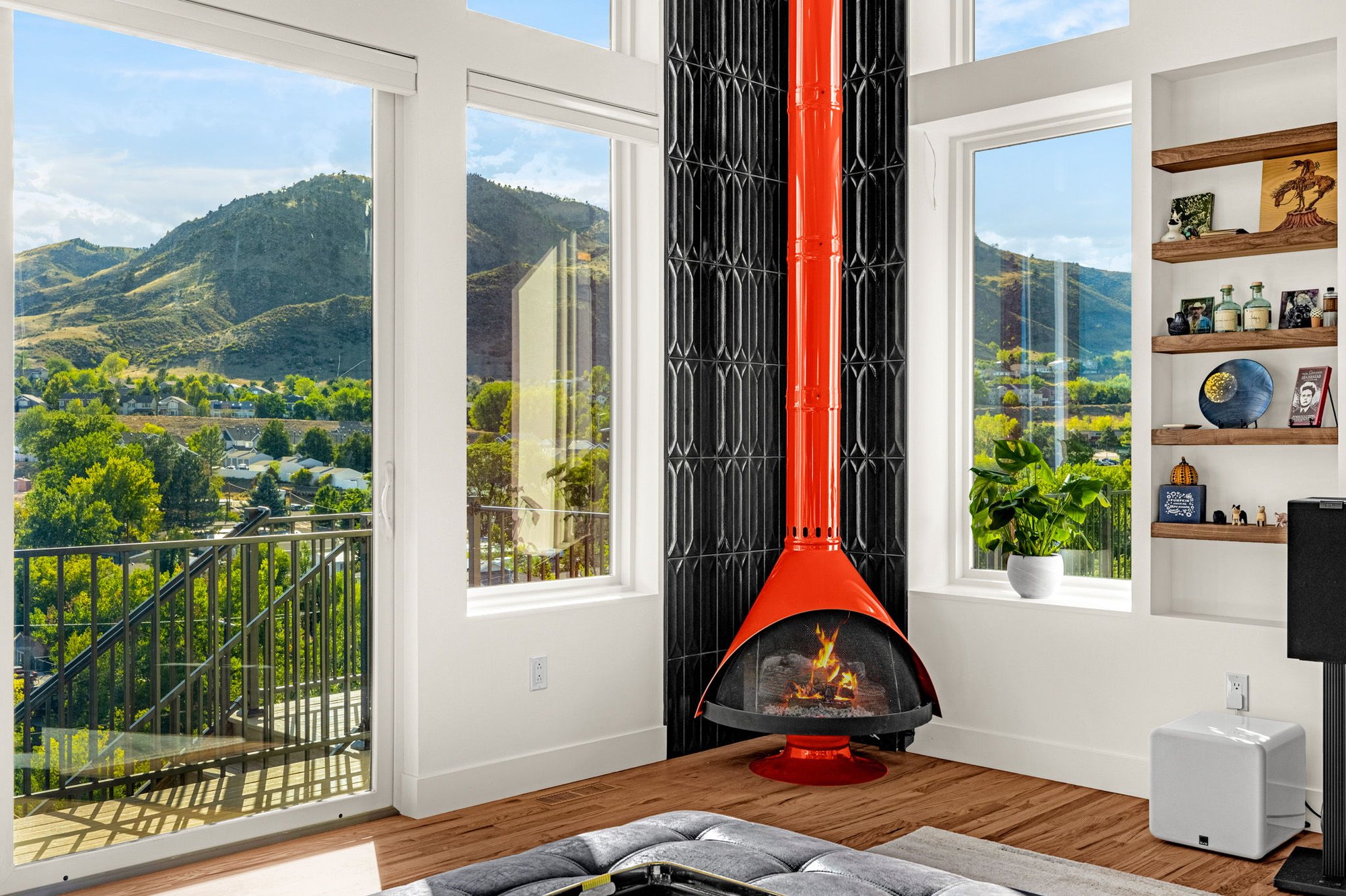 Living room with a red freestanding fireplace against a black textured tile chimney breast