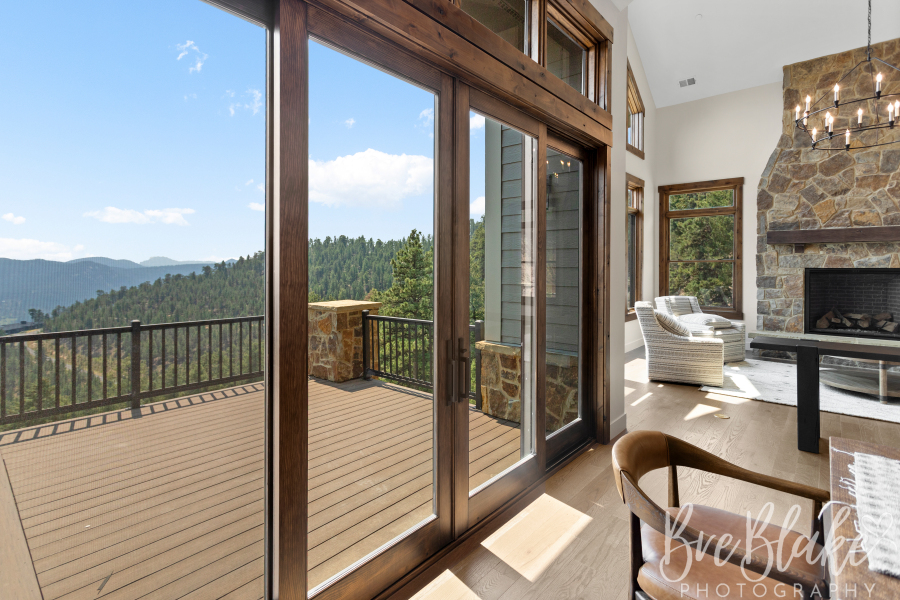 Full-height glass doors opening the great room to the deck and surrounding foothills