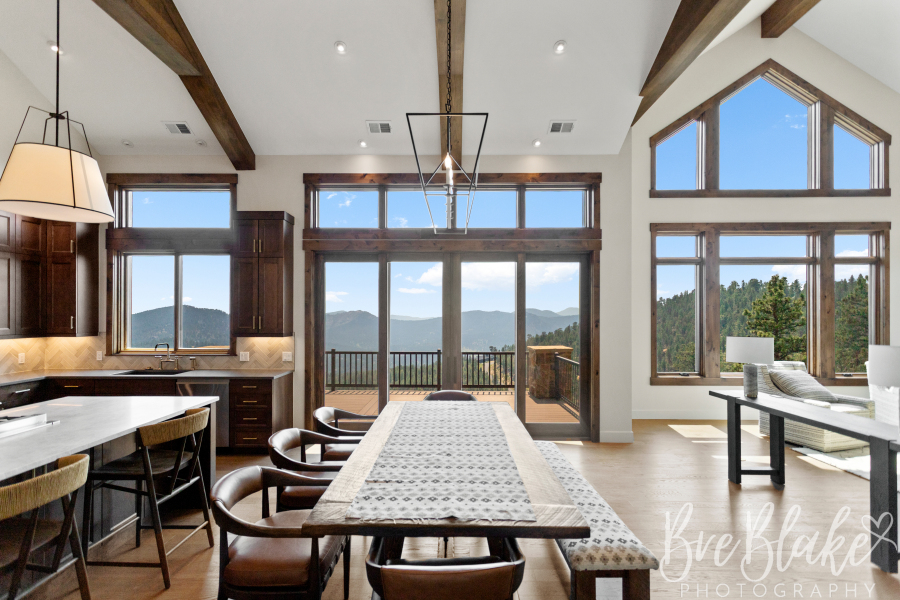 Open kitchen and dining area with vaulted ceilings, exposed beams and foothills views